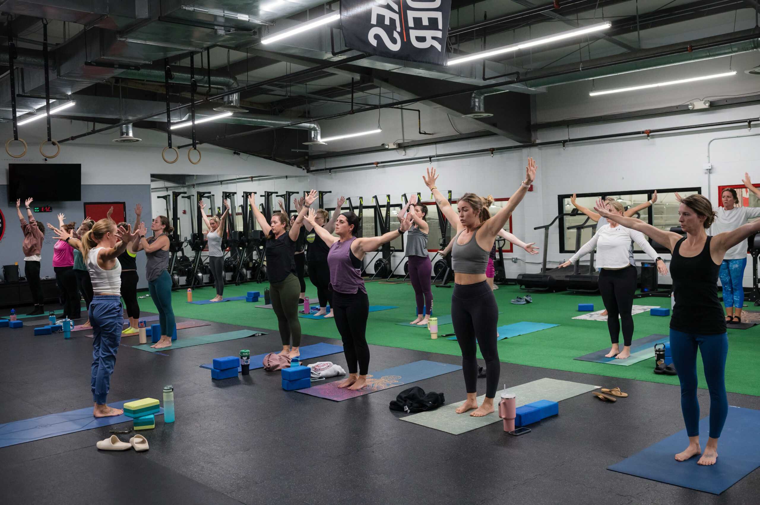 Group yoga class with arms raised in warrior pose
