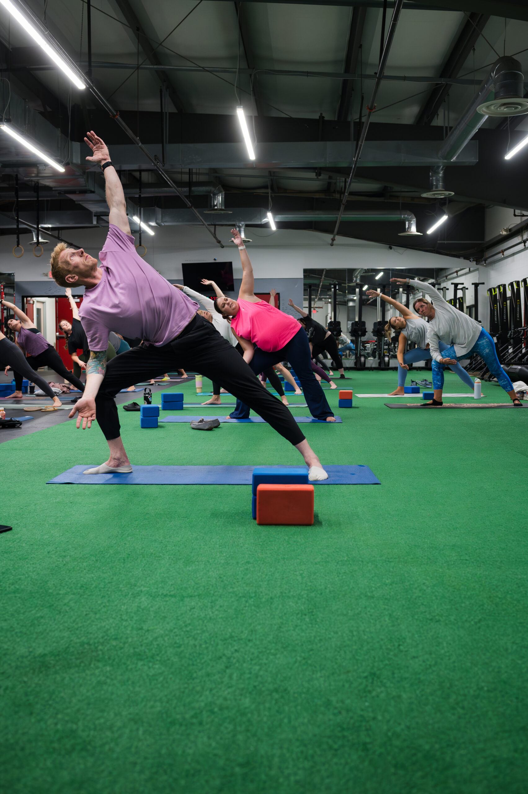 Yoga student in triangle pose using a block